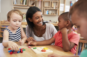 Teacher_with_students_and_blocks_300_198_int_c1-1x.png